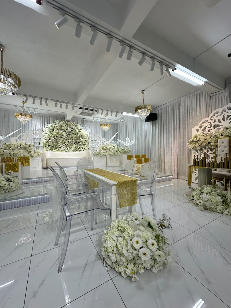 Pelamin putih berhias bunga di dalam Molyana Banquet Hall