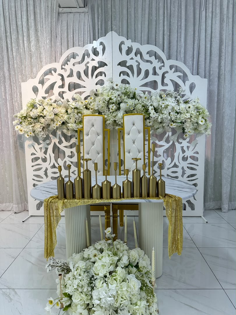 Meja pengantin berhias bunga putih dan lilin emas