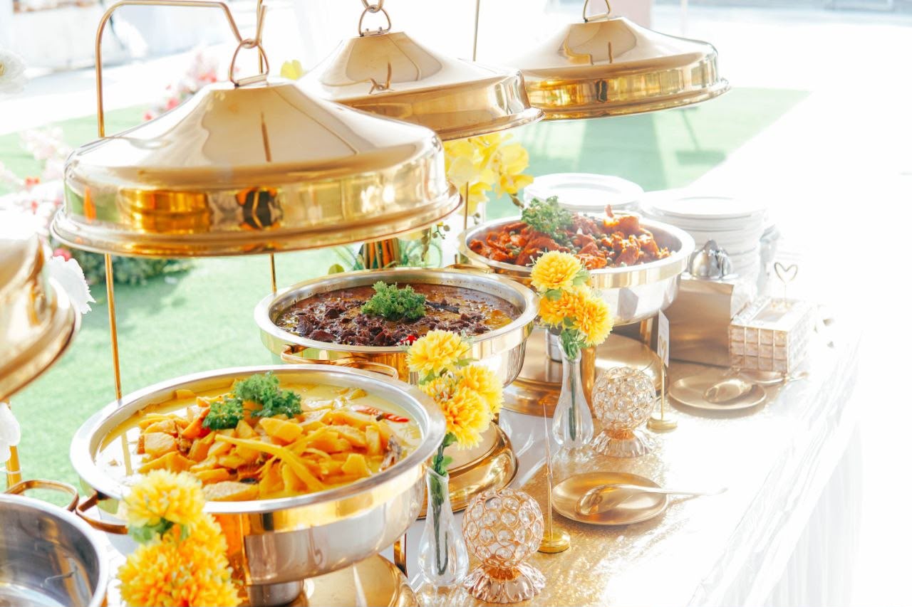 Stesen makanan utama dengan tiga hidangan lauk dalam chafing dish emas