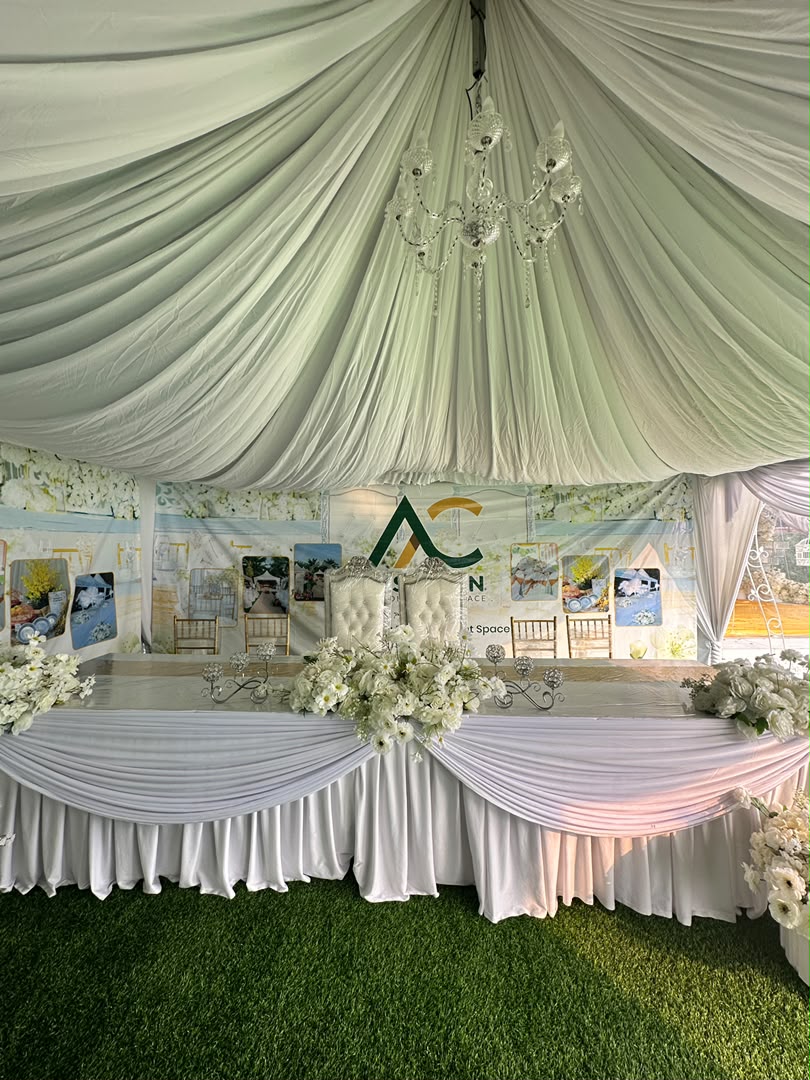Meja utama berhias putih dengan candelier di ruang outdoor