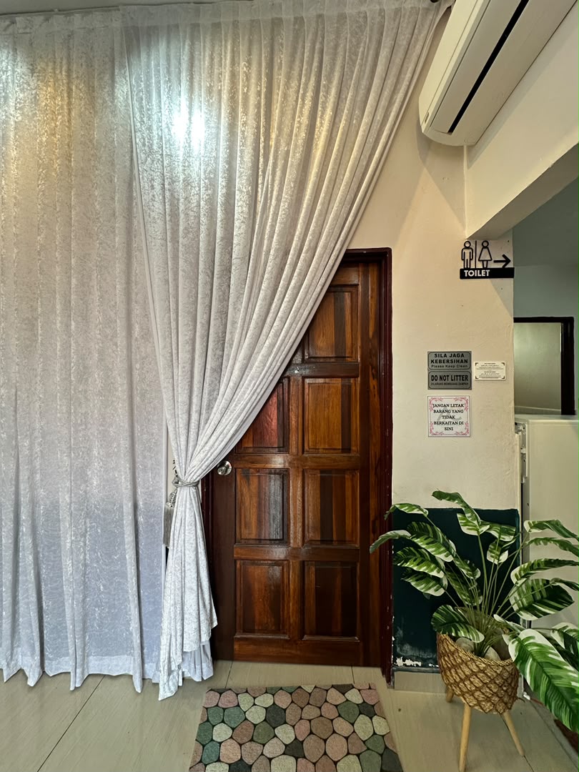 Laluan masuk VIP lounge dengan langsir putih dan pokok hiasan