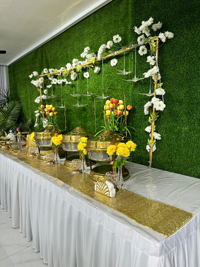 Meja buffet berhias emas dengan chafing dish di dalam dewan