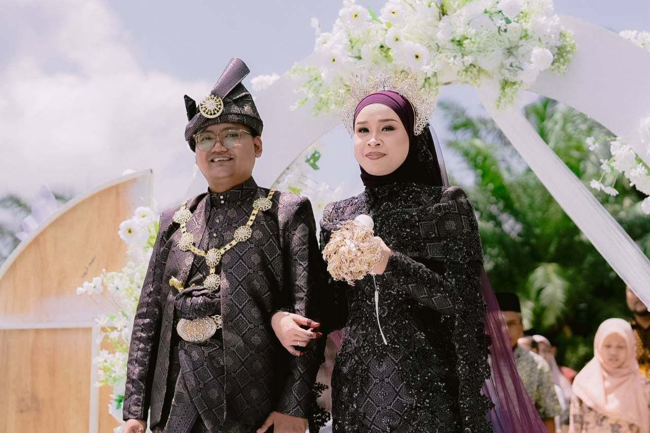 Izzati dan Faris berpakaian hitam di bawah gerbang bunga luar