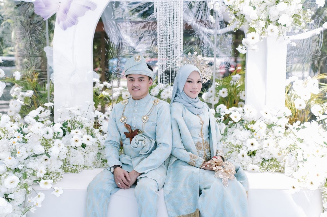 Aiman dan Liyana berpakaian biru lembut di pelamin bunga putih